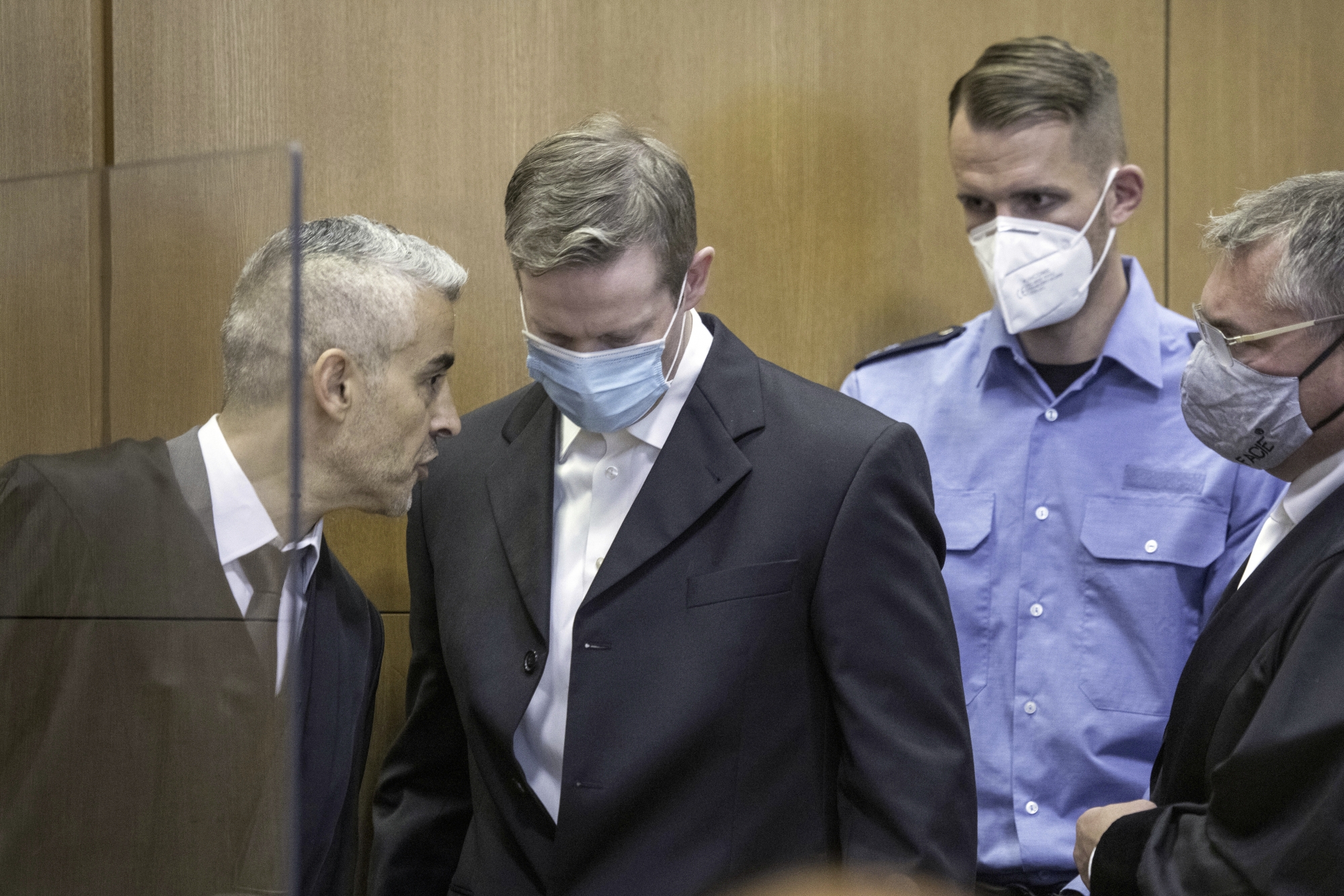 Stephan Ernst, second left, talks to his lawyers Mustafa Kaplan, left, and Frank Henning, right, after he arrived in the courtroom of the Higher Regional Court on the first day of the trial, in Frankfurt, Germany, Tuesday, June 16, 2020. A German court will begin hearing the case against two far-right extremists accused of killing a regional politician. The execution-style slaying of Walter Luebcke shocked the country last year. Stephan Ernst, a 46-year-oldÂ with previous convictions for violent anti-migrant crimes, will appear in the Frankfurt regional court accused of murder, attempted murder, serious bodily harm and firearms offenses. (Thomas Lohnes/Pool Photo via AP)