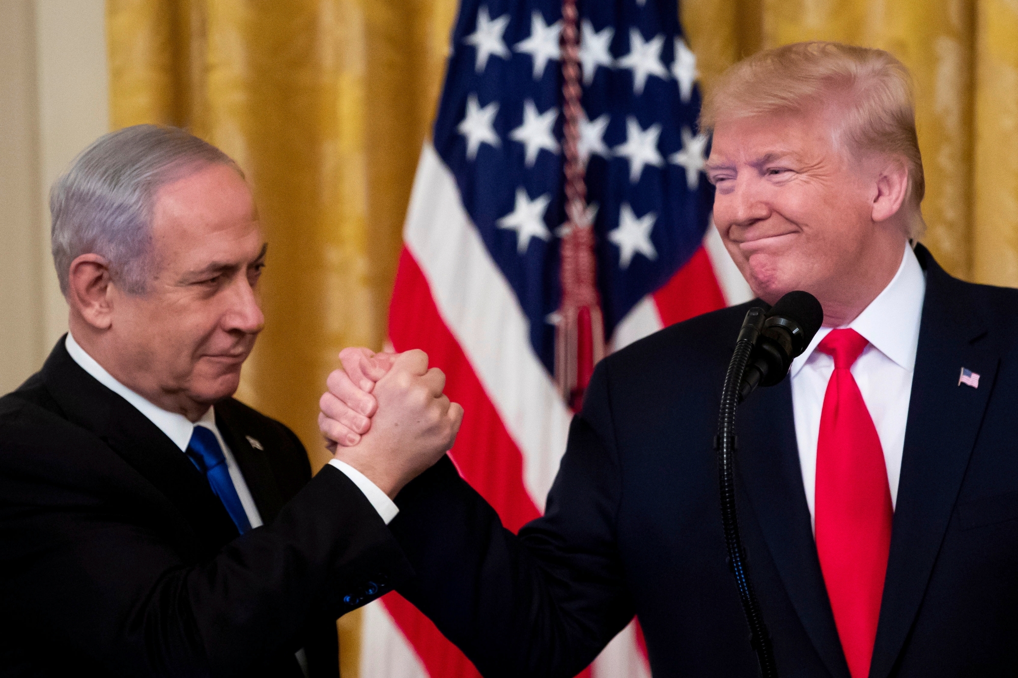 epa08173197 US President Donald J. Trump (R) shakes hands with Prime Minister of Israel Benjamin Netanyahu while unveiling his Middle East peace plan in the East Room of the White House, in Washington, DC, USA, 28 January 2020. US President Donald J. Trump's Middle East peace plan is expected to be rejected by Palestinian leaders, having withdrawn from engagement with the White House after Trump recognized Jerusalem as the capital of Israel. The proposal was announced while Netanyahu and his political rival, Benny Gantz, both visit Washington, DC.  EPA/MICHAEL REYNOLDS
ArcInfo