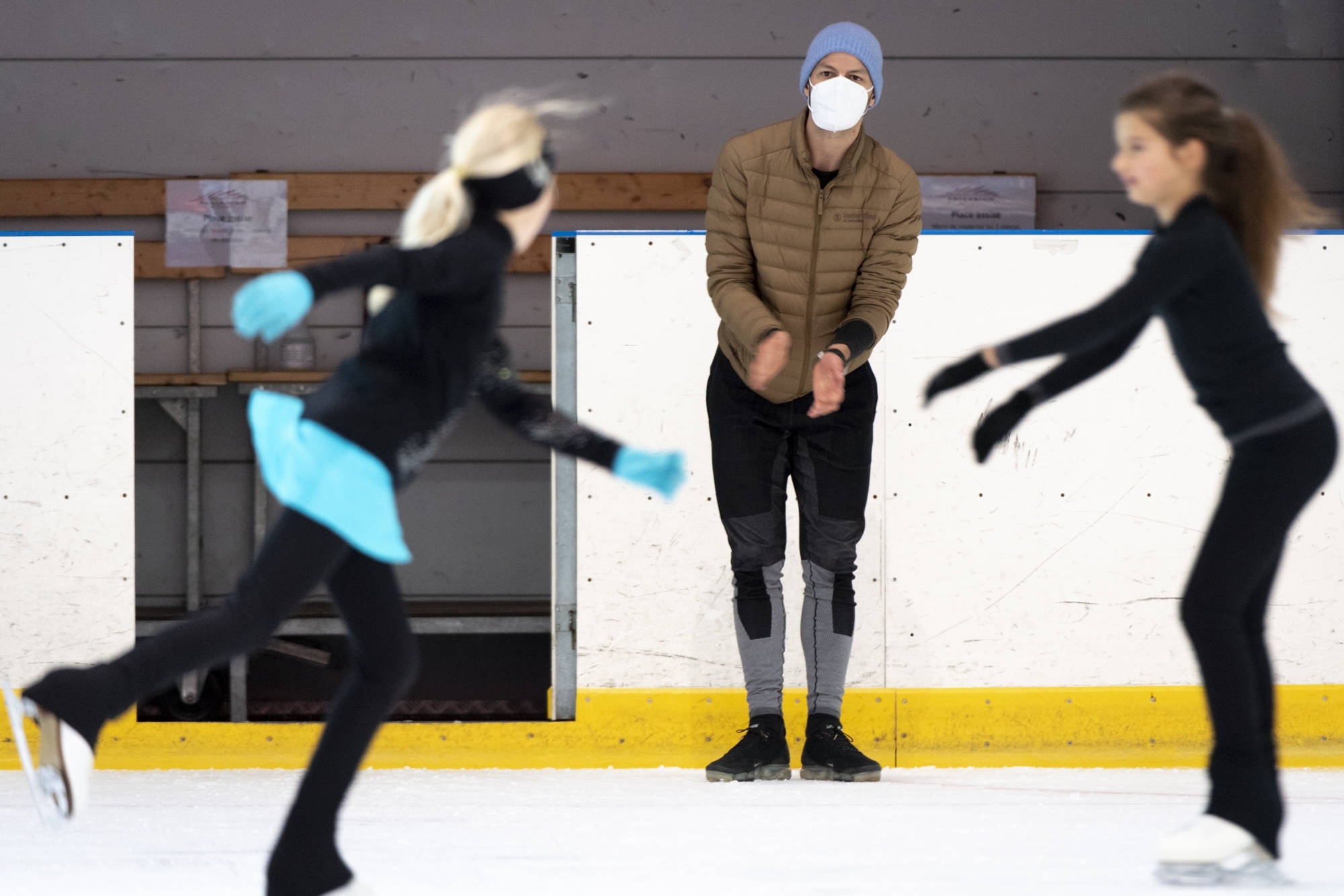 Masque sur le visage, bonnet sur la tête, Stéphane Lambiel donne de la voix et soutient par le geste ses élèves lors de la reprise des cours de la Skating School of Switzerland.