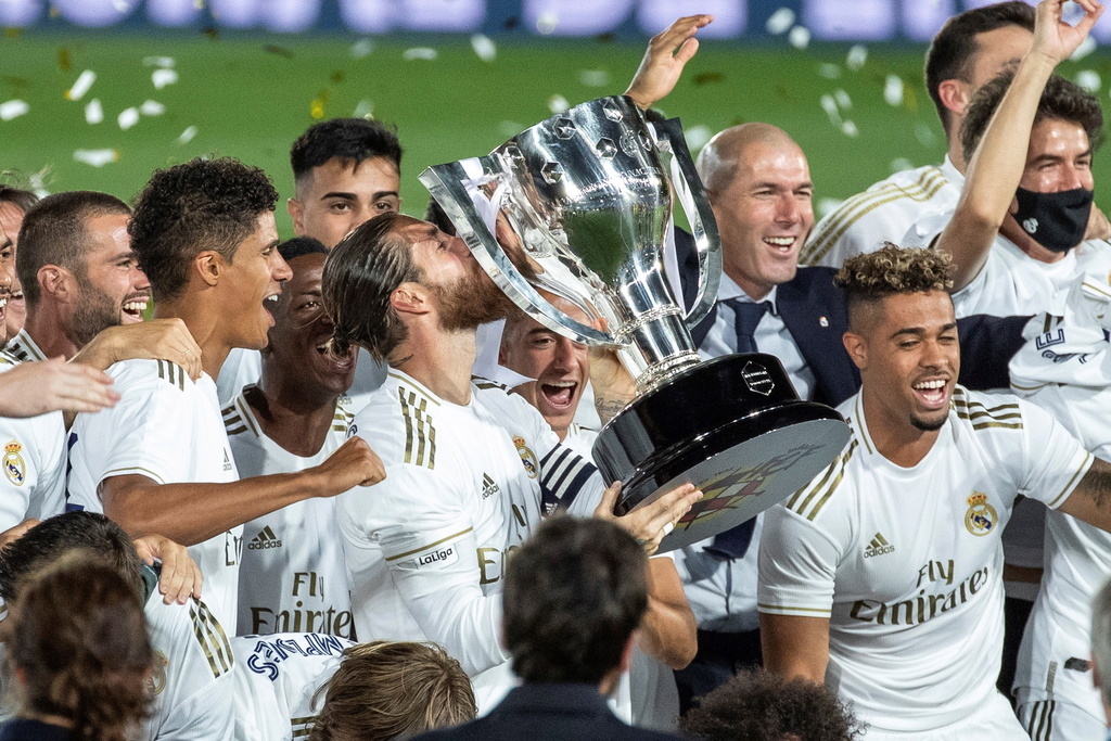 Le capitaine du Real Madrid, Sergio Ramos, embrasse le trophée de Liga, entouré de ses coéquipiers et de son entraîneur, Zinédine Zidane. C'est le 34e titre de champion national du club de la capitale espagnole.