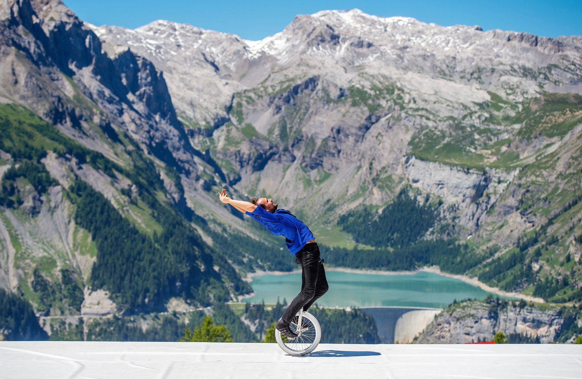 Le spectacle "Insaisissable" sur l'alpage, avec une vue imprenable sur le barrage de Zeuzier. Cirque au sommet offre une grande variété d'expériences cet été à Crans-Montana.