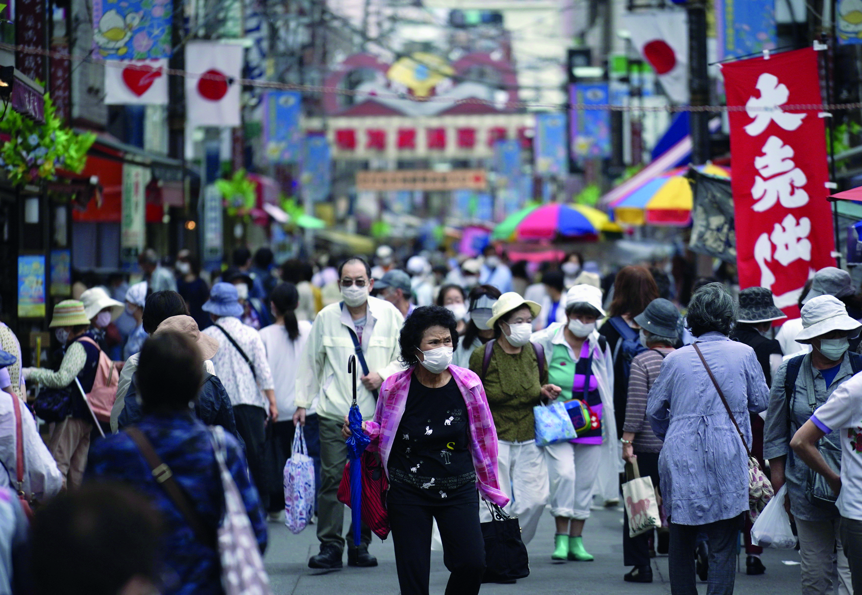 FILE - In this June 24, 2020, photo, a street is crowded by shoppers in Tokyo. A quarterly Bank of Japan survey showed Wednesday, July 1, 2020, manufacturers' sentiments plunging to a low not seen in more than a decade, as the coronavirus pandemic crushes exports and tourism, the mainstay of this nation's economy. (AP Photo/Eugene Hoshiko, File) ArcInfo