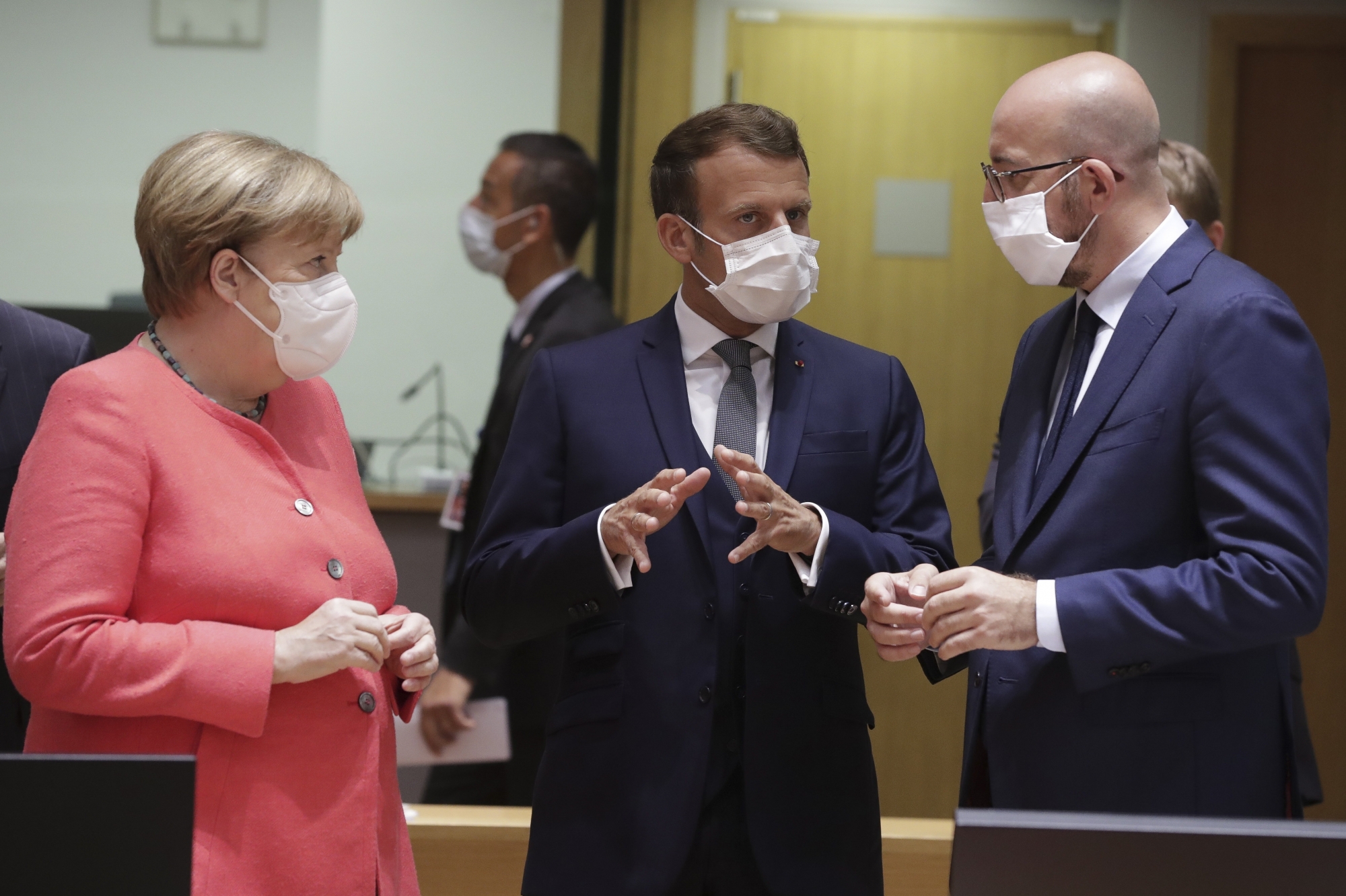 epa08551237 (L-R) Germany's Chancellor Angela Merkel, French President Emmanuel Macron and European Council President Charles Michel chat at the start of an EU summit at the European Council building in Brussels, Belgium, 17 July 2020. European Union nations leaders meet face-to-face for the first time since February to discuss plans responding to coronavirus crisis and new long-term EU budget at the special European Council on 17 and 18 July.  EPA/STEPHANIE LECOCQ / POOL ArcInfo