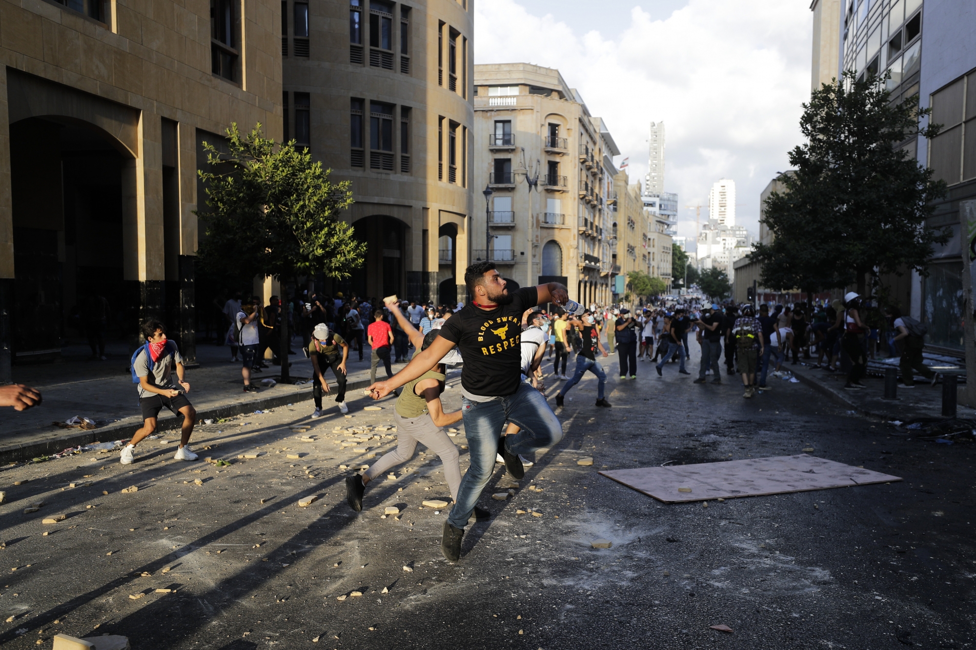 People throw stones during anti-government protest following Tuesday's massive explosion which devastated Beirut, Lebanon, Sunday, Aug. 9. 2020. (AP Photo/Hassan Ammar) ArcInfo