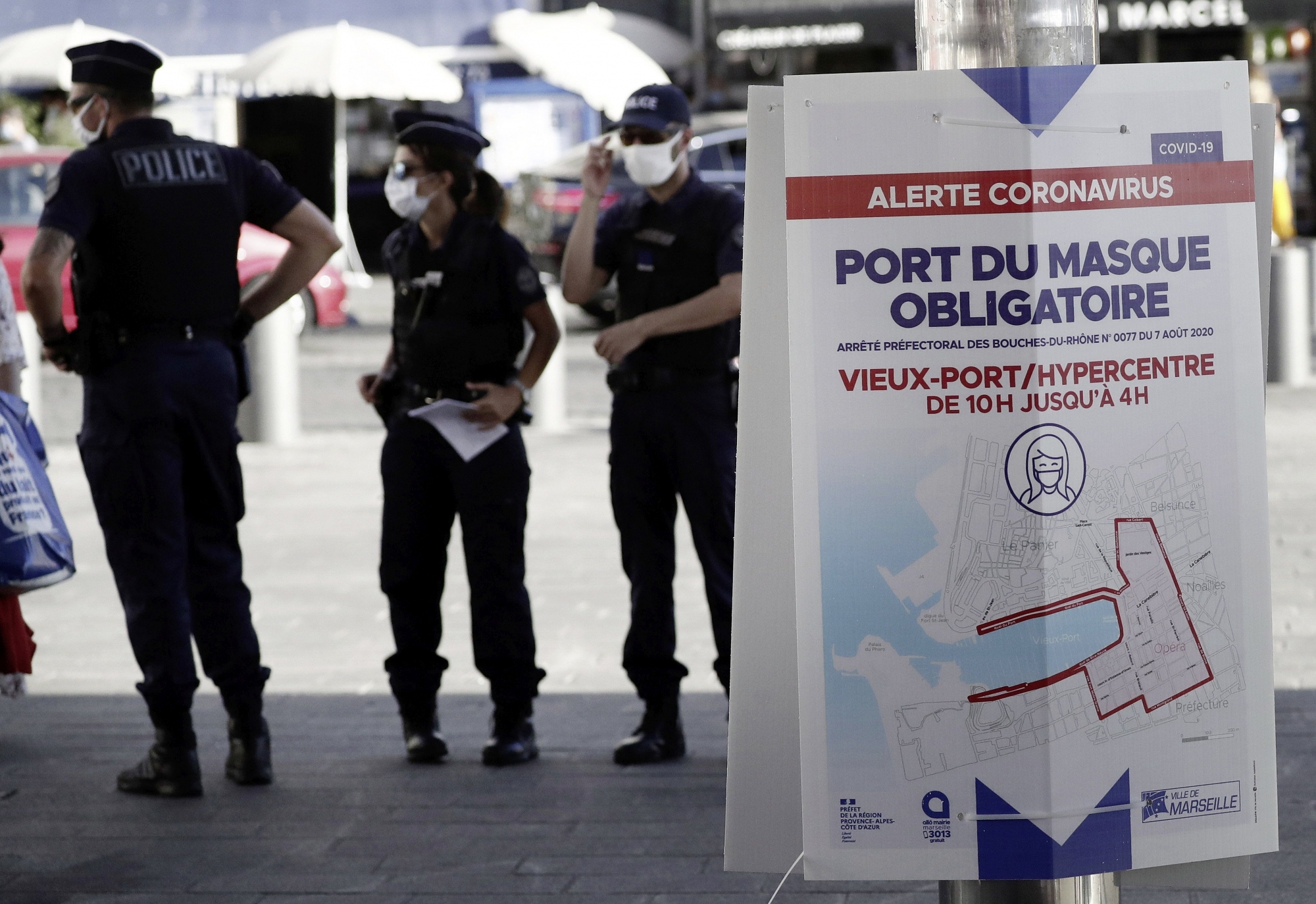 epa08609635 French policemen wearing protective face masks control people at a test station for  Covid-19 coronavirus in Marseille, France, 17 August 2020. Marseille has been declared a zone of 'active circulation' for the Covid19 coronavirus, as cases surged in recent weeks. The banner reads 'wearing a mask is an obligation at old harbour and citycenter'.  EPA/GUILLAUME HORCAJUELO
