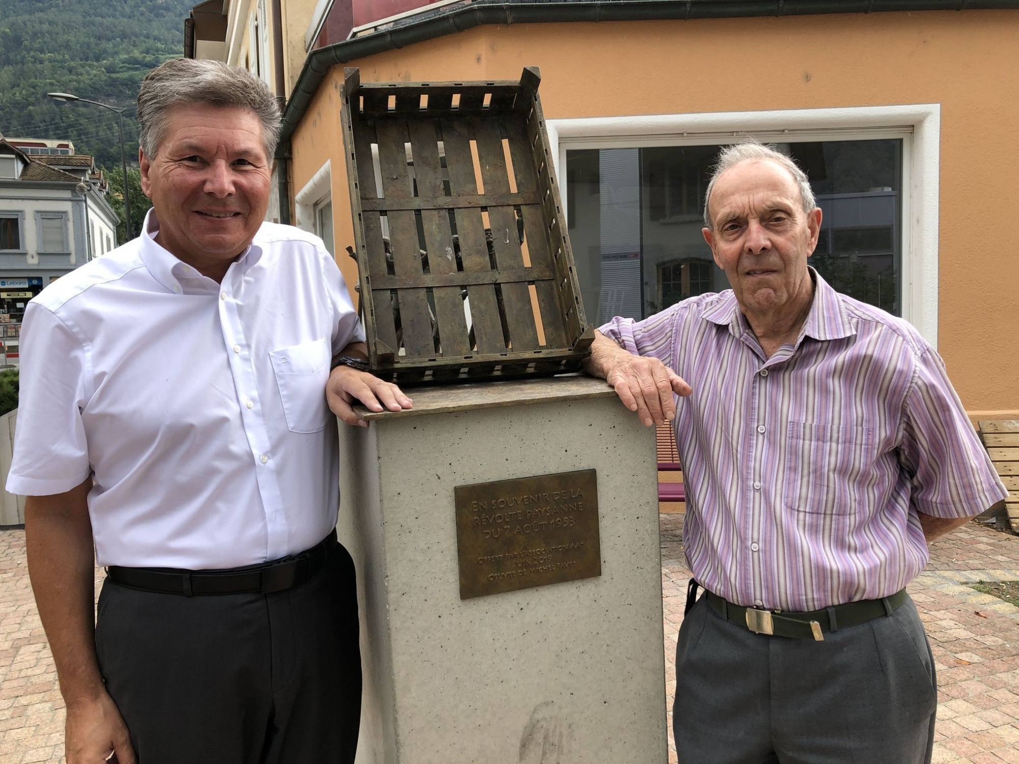 Le président de Saxon Christian Roth (à g.) et Marc Thomas, qui a participé aux événements de 1953, devant la sculpture de Michel Favre posée l’an dernier sur la place de la Révolte.