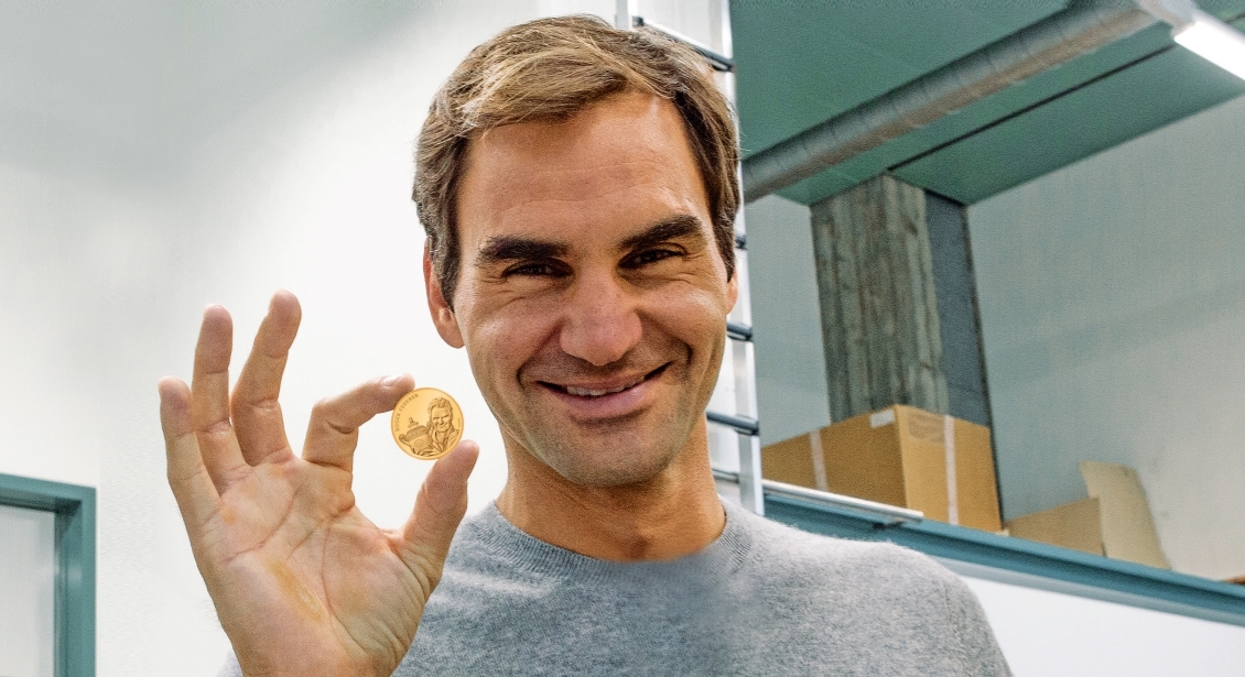 Roger Federer présente la pièce d'or où il soulève fièrement le trophée de Wimbledon qu'il vient tout juste de remporter en 2009.